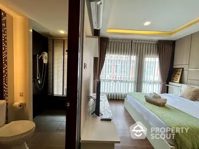 Modern bedroom with ensuite bathroom featuring stylish decor and large window