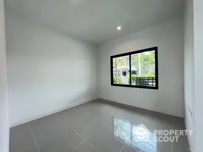 Spacious empty room with large window and glossy tiled floor