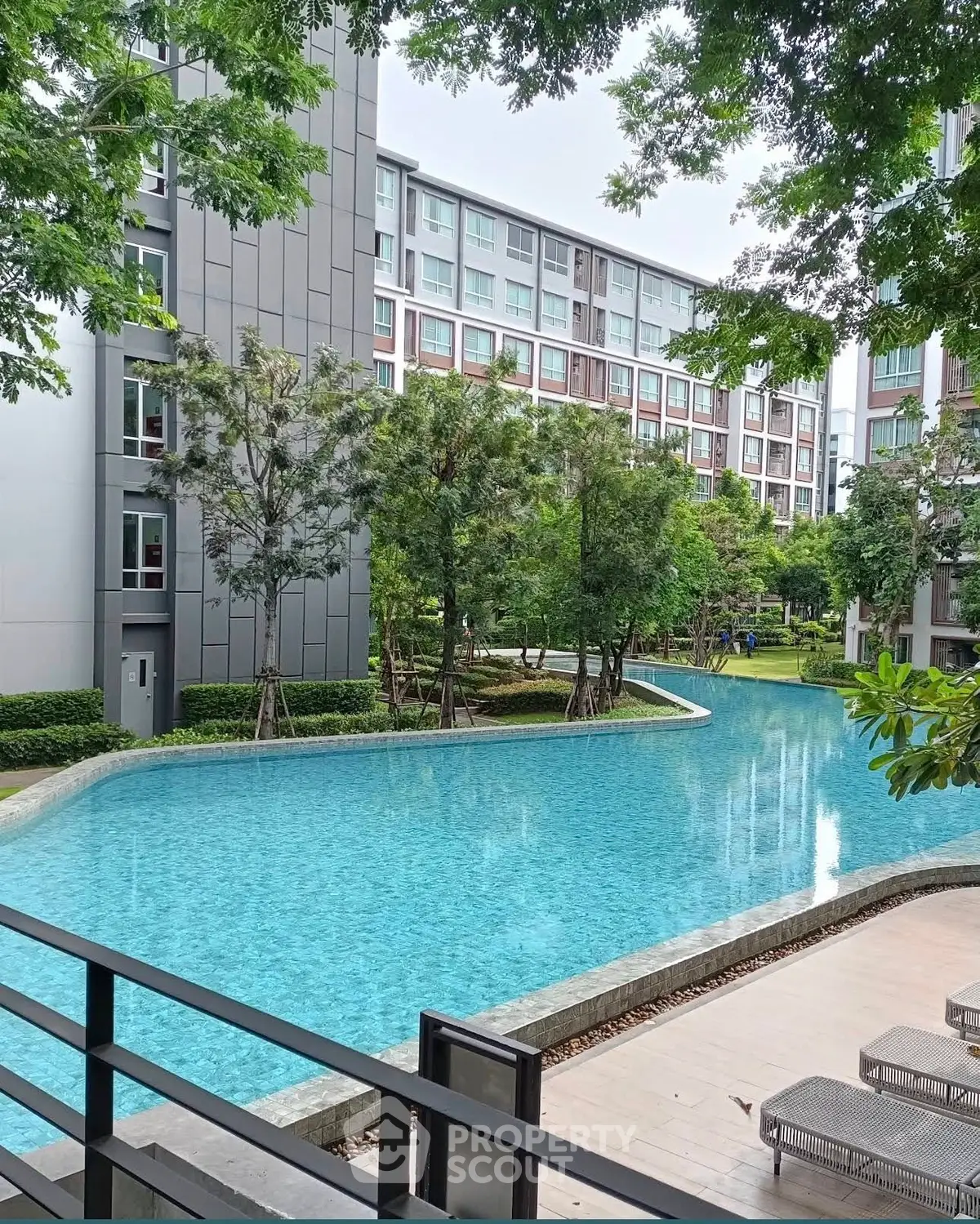 Luxurious residential complex with serene pool and lush greenery, perfect for modern living.