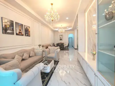 Luxurious living room with elegant chandeliers and plush sofas in a modern apartment.