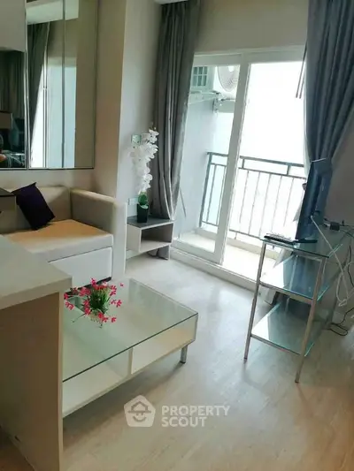 Modern living room with balcony access, featuring sleek furniture and natural light.