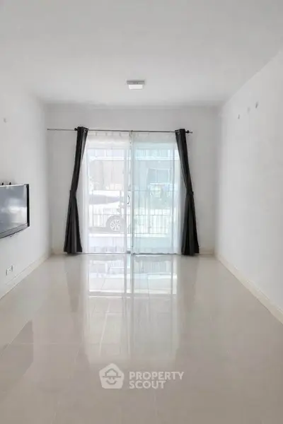 Spacious living room with large windows and modern minimalist design.
