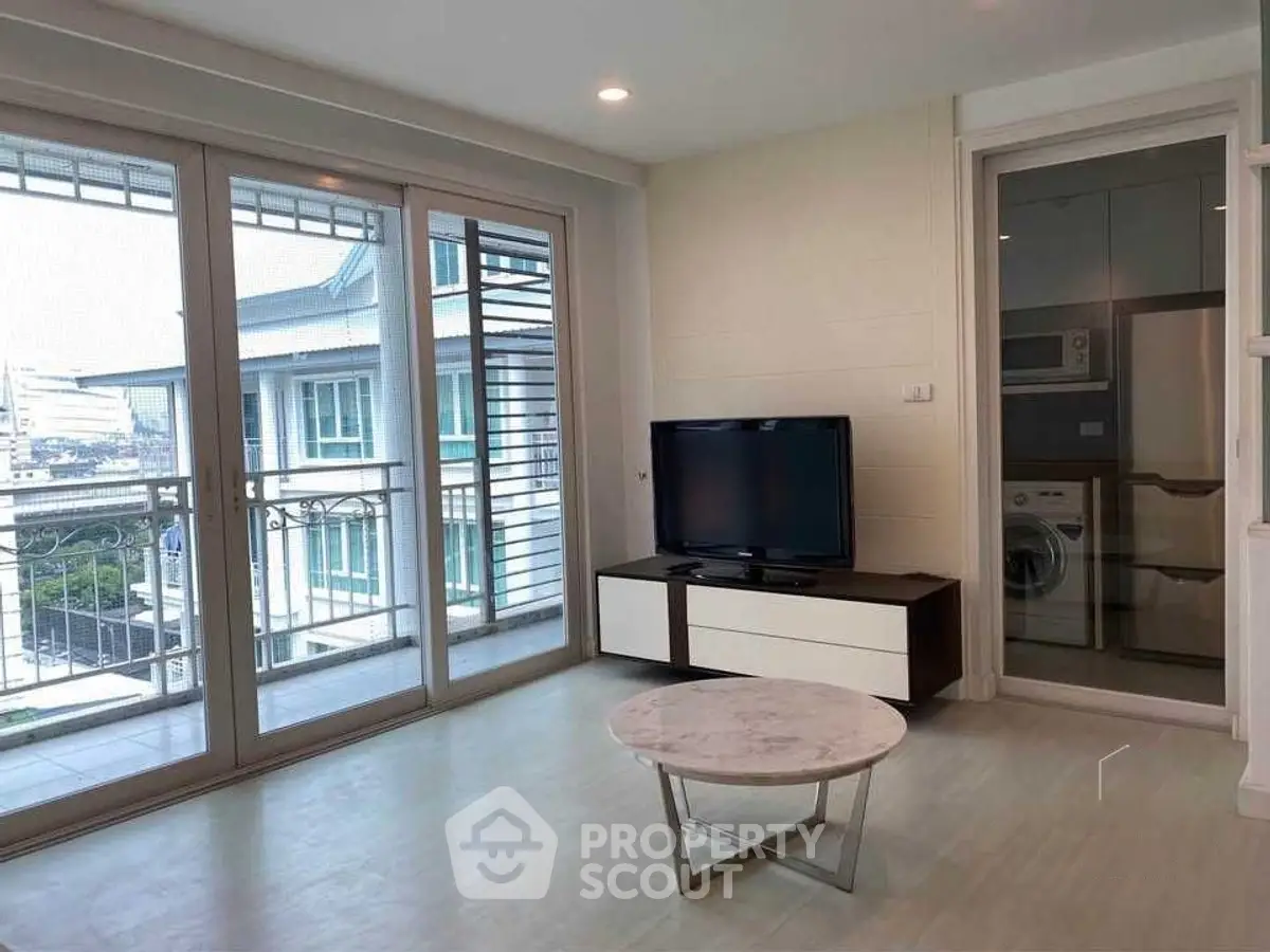 Modern living room with balcony view and laundry area
