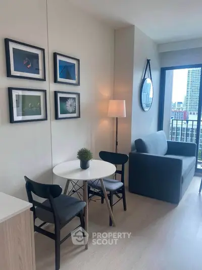 Modern living room with stylish decor and city view, featuring a cozy seating area and elegant wall art.