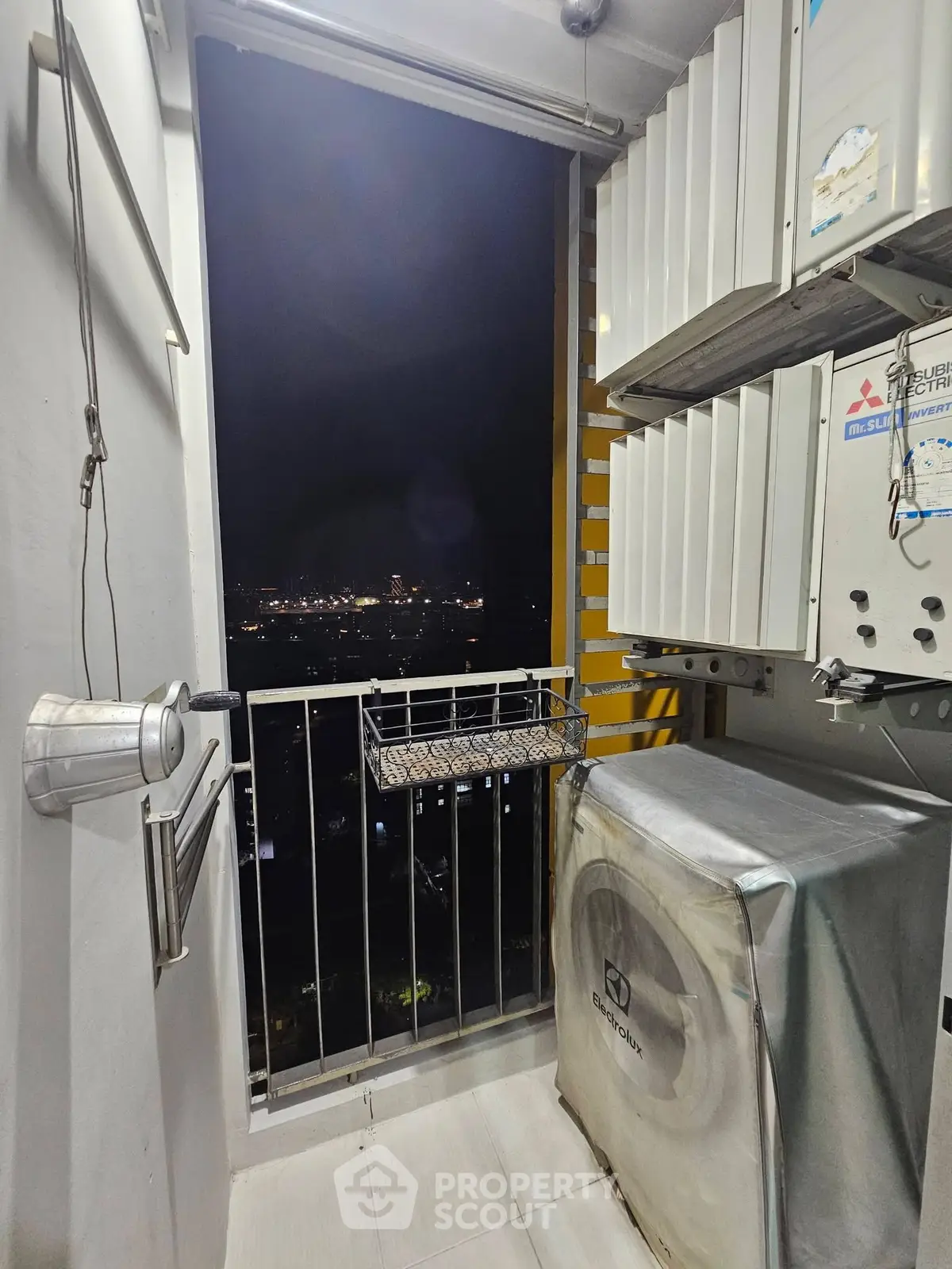 Compact balcony with city view and laundry setup, perfect for urban living.