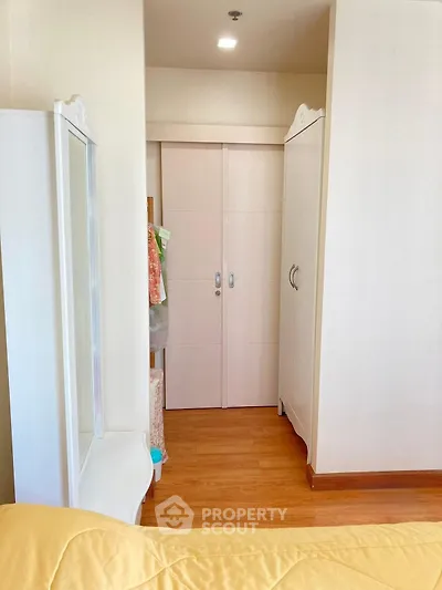 Cozy bedroom with elegant wardrobe and wooden flooring, perfect for modern living.