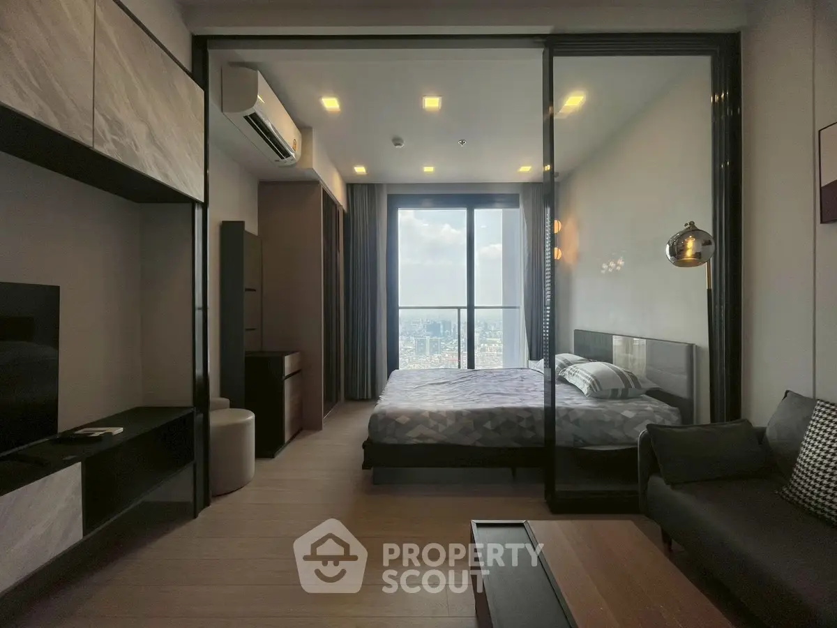 Modern bedroom with glass partition and city view in high-rise apartment