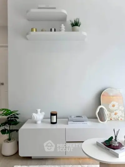 Modern living room with sleek white furniture and decorative shelves, creating a minimalist and stylish ambiance.