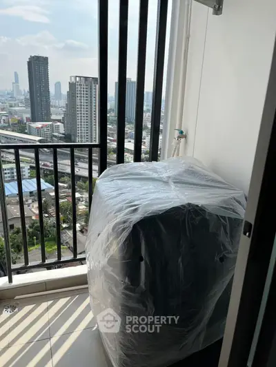 High-rise balcony with city view and covered appliance