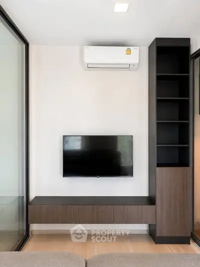 Modern living room with sleek TV setup and built-in shelving, perfect for contemporary living.