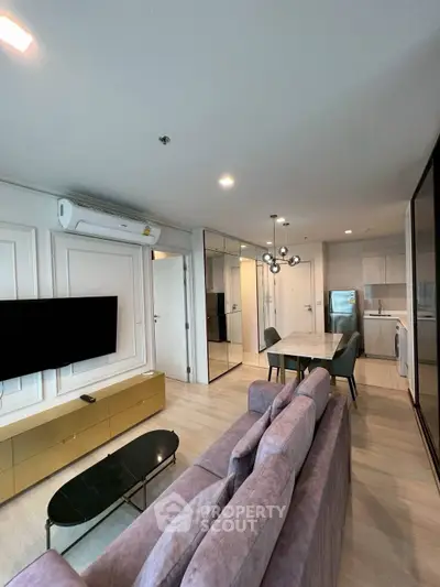 Modern living room with stylish furniture and open kitchen layout in a contemporary apartment.