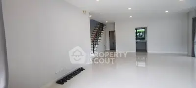 Spacious modern living room with sleek staircase and glossy floors
