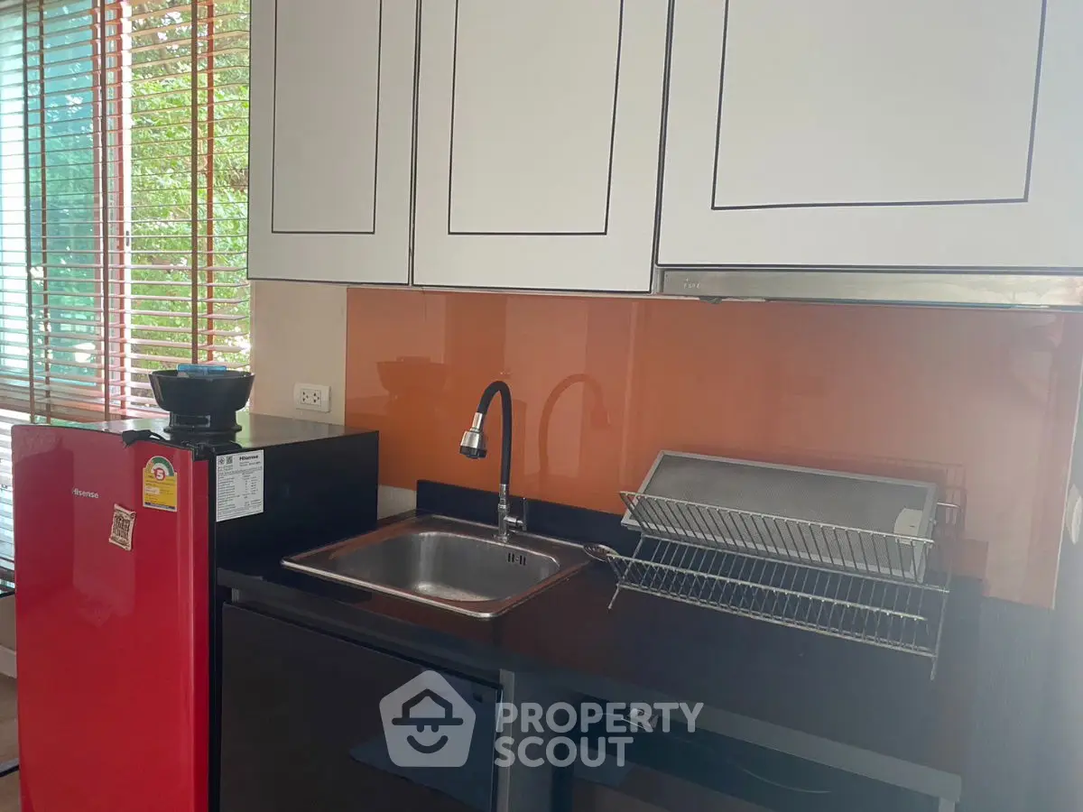 Modern kitchen with red fridge and sleek cabinetry
