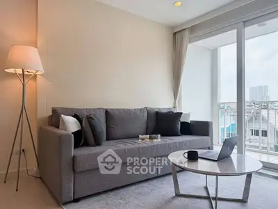 Modern living room with gray sofa, floor lamp, and balcony view.