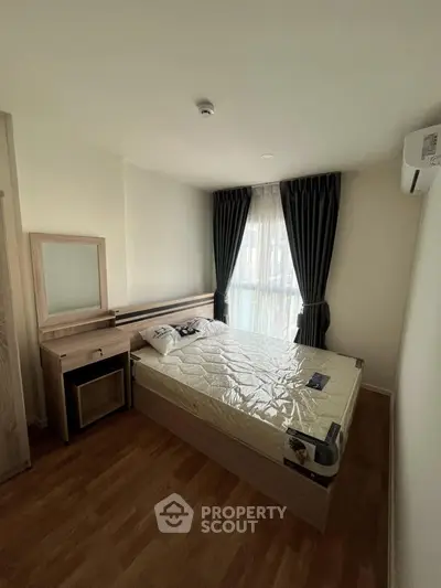 Cozy bedroom with natural light, featuring a modern bed and stylish curtains, perfect for relaxation.