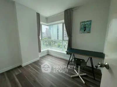Bright study room with large windows and modern decor in urban apartment.