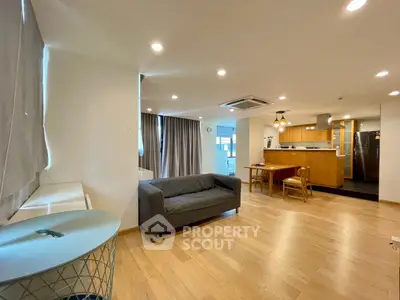 Spacious open-plan living room with modern kitchen and wooden flooring