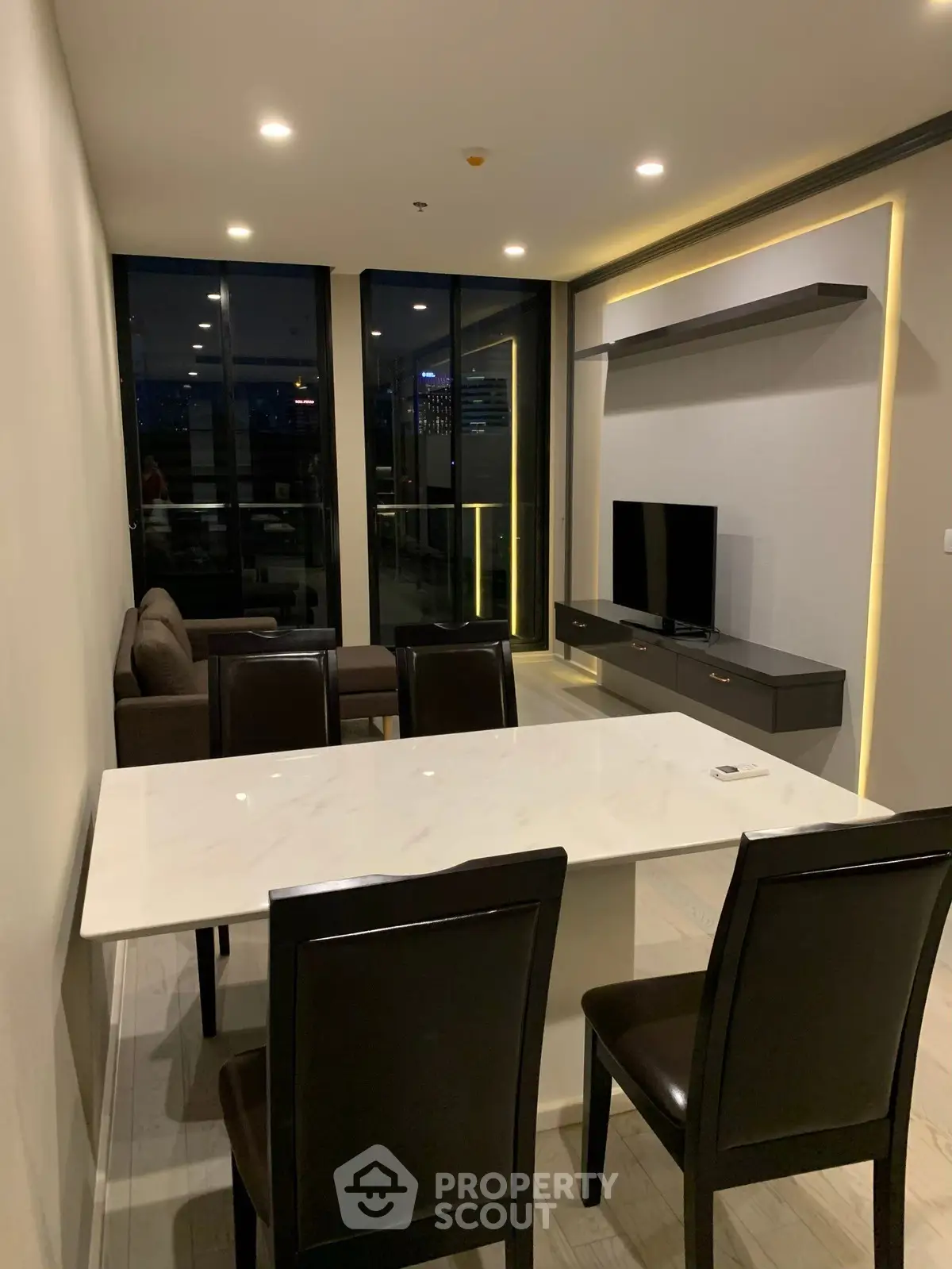 Modern living room with sleek furniture and city view balcony