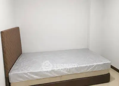 Minimalist bedroom with simple bed and white walls, perfect for cozy living.