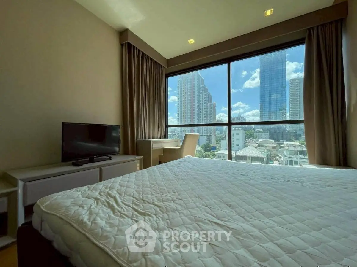 Spacious bedroom with city view and natural light in modern apartment