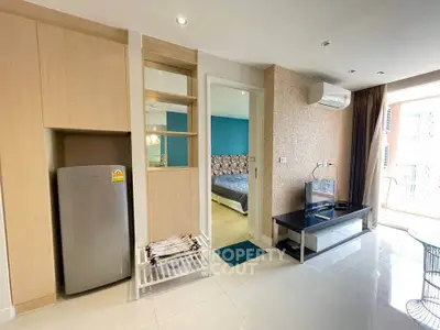 Modern living room with sleek furniture and adjacent bedroom view.