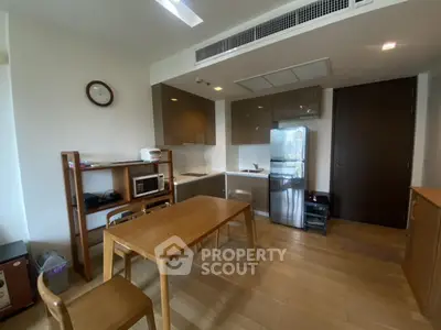 Modern kitchen with wooden dining table and sleek appliances in cozy apartment