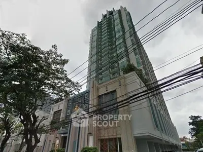 Stunning high-rise building with modern architecture and lush greenery in urban setting.