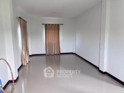 Spacious empty room with glossy tiled floor and large windows with curtains, ideal for customization.