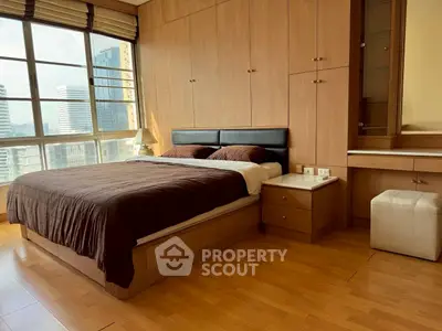 Luxurious bedroom with city view, featuring elegant wooden furnishings and large windows for natural light.