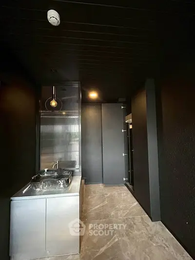 Modern minimalist kitchen with sleek black design and stainless steel appliances.