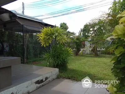 Charming garden view with lush greenery and tiled patio area