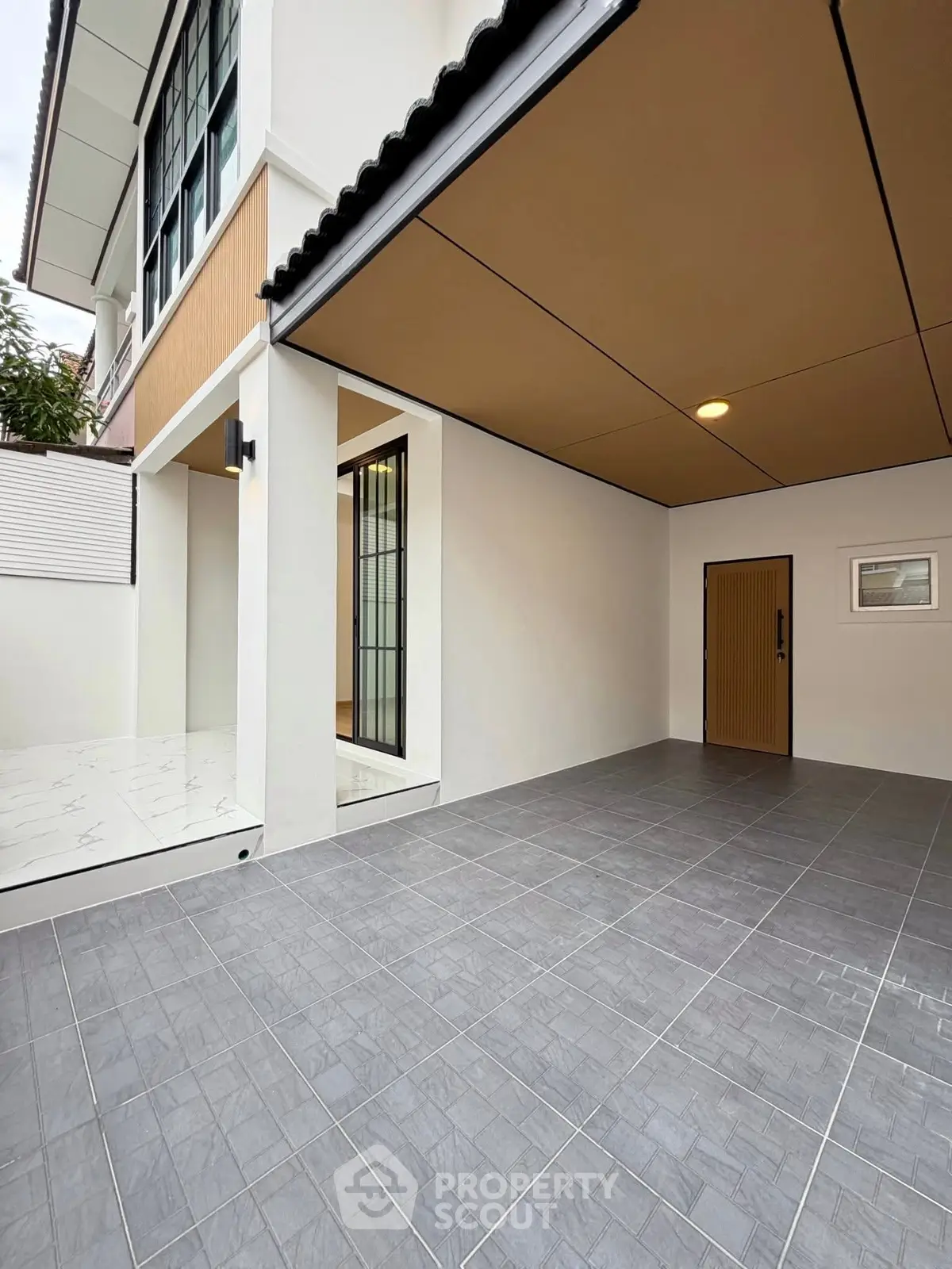 Modern home exterior with spacious tiled patio and sleek design.