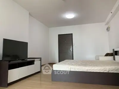 Spacious bedroom with modern furniture and sleek TV setup