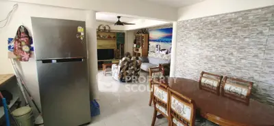 Spacious living room with dining area and modern fridge, perfect for family gatherings.