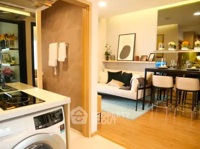 Modern open-plan living room with stylish kitchen and washing machine