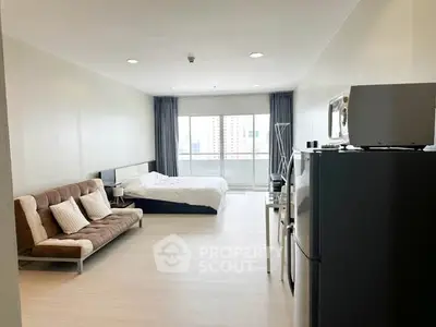 Spacious studio apartment with modern furnishings and city view balcony.