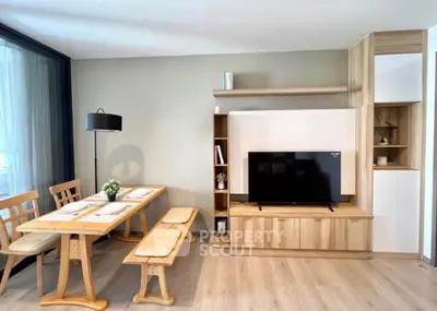 Modern living room with stylish wooden furniture and large TV, perfect for cozy family gatherings.