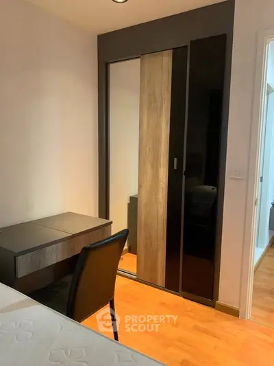 Modern bedroom with sleek wardrobe and stylish desk, perfect for urban living.