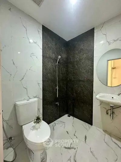 Modern bathroom with marble tiles and sleek fixtures in a contemporary apartment.
