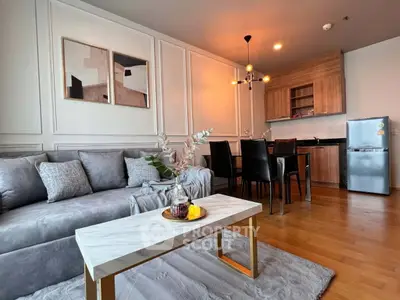 Modern living room with stylish decor and open kitchen layout in a cozy apartment.