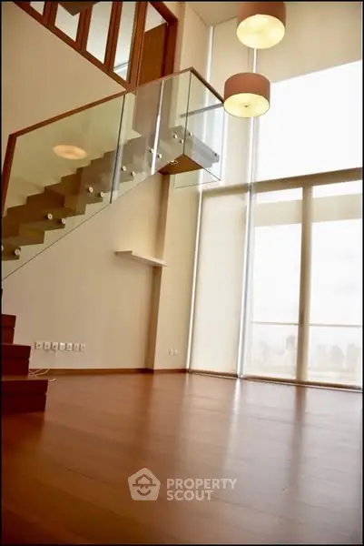Luxurious modern living room with high ceilings and elegant staircase