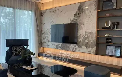 Luxurious modern living room with elegant decor and large TV on marble accent wall.