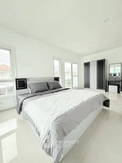 Spacious modern bedroom with large windows and sleek furnishings