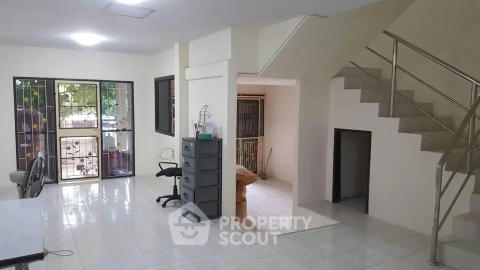 Spacious interior with modern staircase and natural light, ideal for versatile living space.