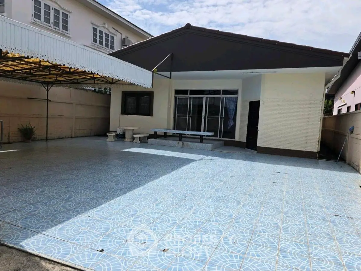 Spacious exterior with tiled patio and covered area, ideal for outdoor activities.