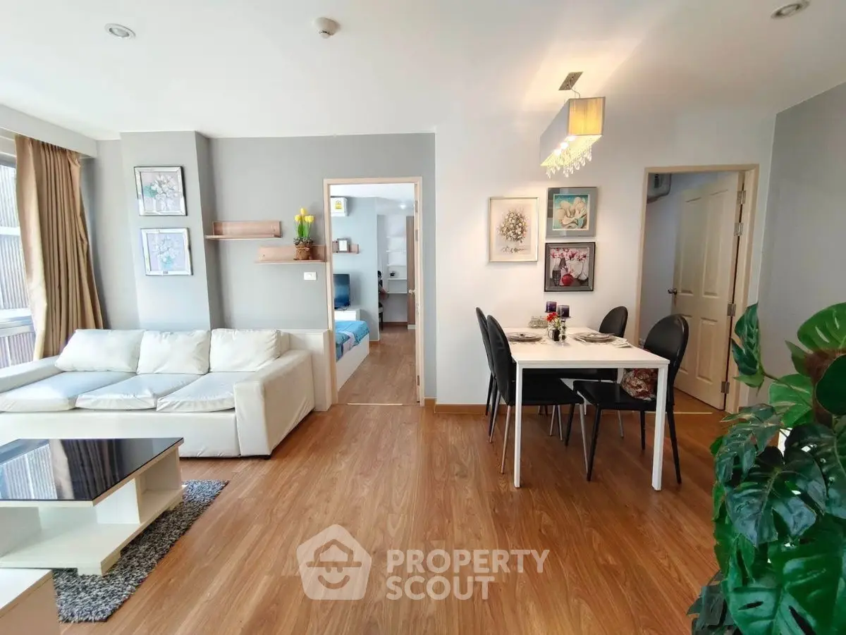 Modern living room with dining area, wooden flooring, and stylish decor in a cozy apartment.