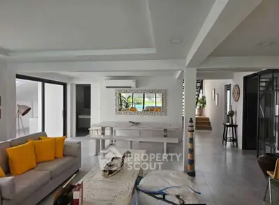 Spacious modern living room with stylish decor and large windows offering natural light.