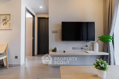 Modern living room with wall-mounted TV and stylish decor in a contemporary apartment.