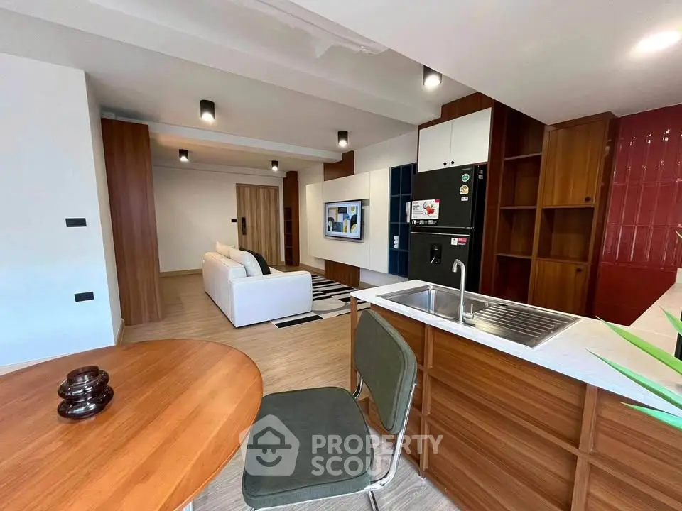 Modern open-plan living room with stylish kitchen and cozy seating area, perfect for entertaining.