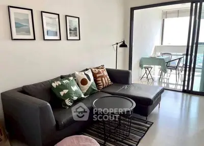 Modern living room with stylish decor and balcony view, perfect for urban living.